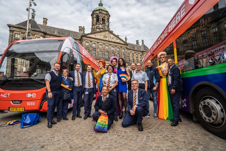 GVB personeel poseert samen met de dragqueens voor de bestickerde voertuigen op de Dam.