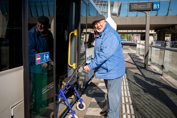 Foto van oude man bij bushalte