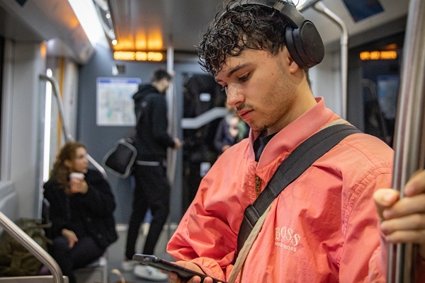 Foto van jongen in metro met een telefoon in zijn hand voor meldnummer