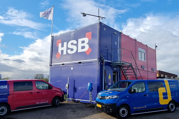 De elektrische busjes van HSB laden op aan de laadpaal op de bouwlocatie