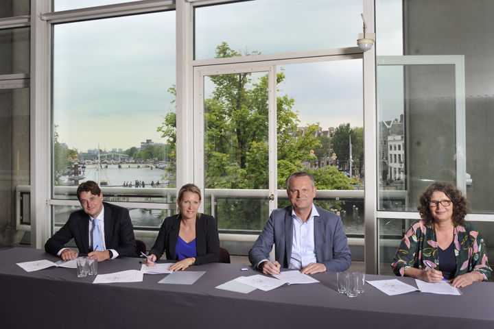 De ondertekening. Vlnr Sebastiaan de Wilde (NS), Astrid Bunt (ProRail), Gerard Slegers (Vervoerregio) en Carolien Schippers (Amsterdam).
