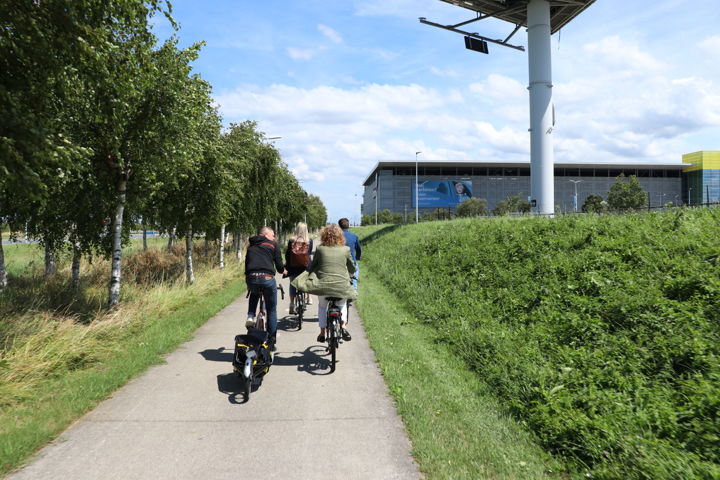 De deelnemers fietsen over het terrein van Schiphol